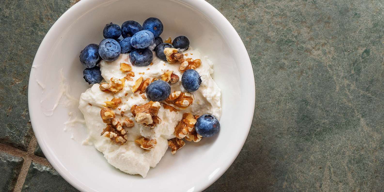 yogurt with fresh garden berries and cereals in reusable picnic